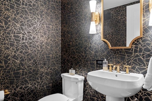 a bathroom with a sink toilet and mirror