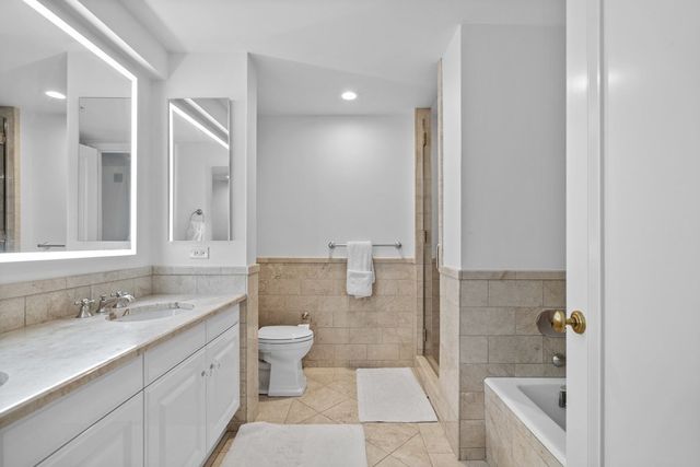 a bathroom with a granite countertop sink mirror and toilet