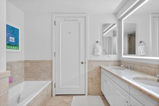 a bathroom with a granite countertop tub sink and mirror