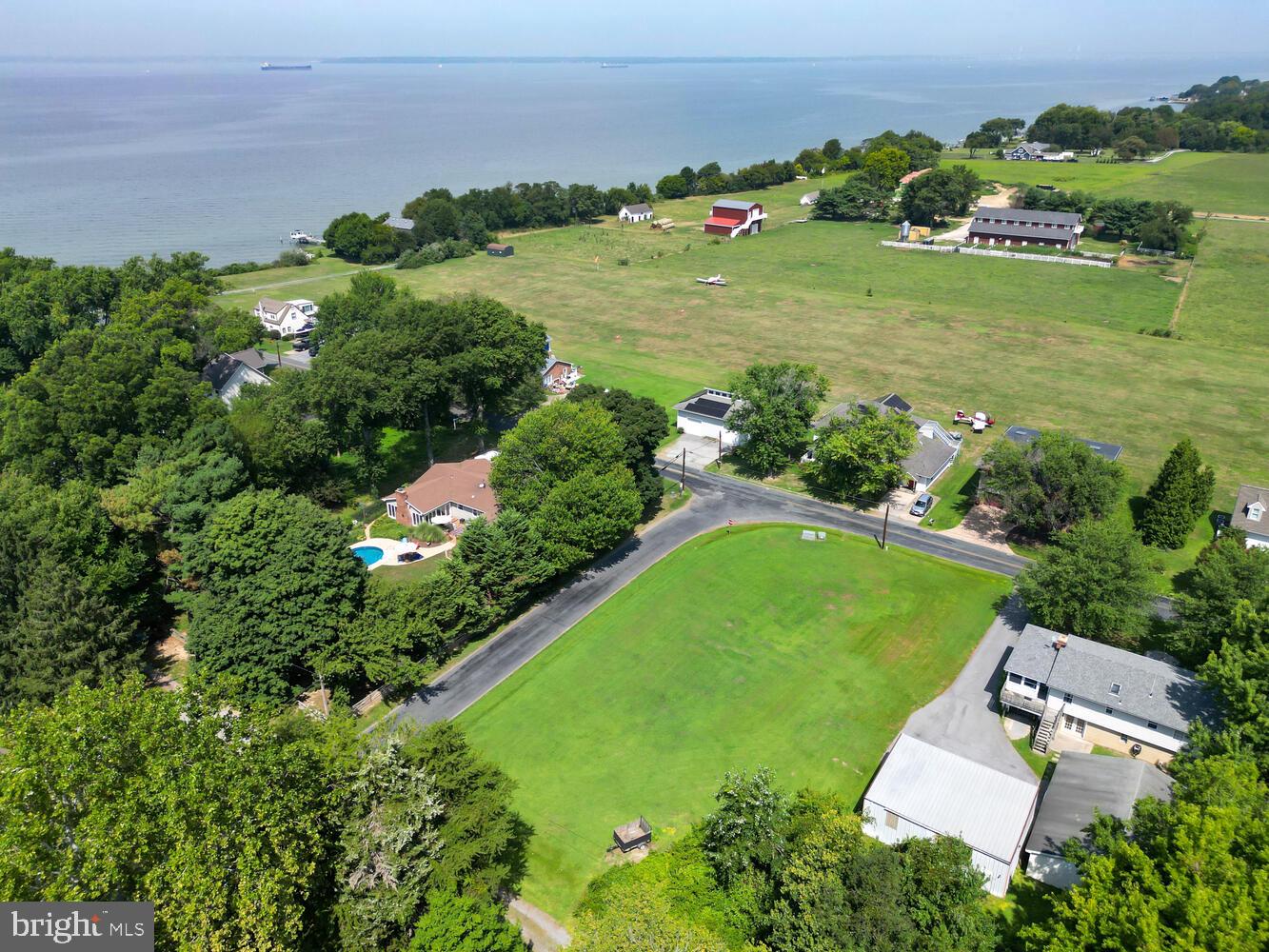 an aerial view of a residential houses with outdoor space and lake view