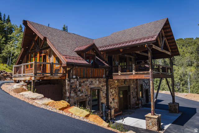 1667 West Tollgate Cyn Road Coalville, UT 84017 - Photo 4 of 61 Rustic-modern residence featuring a stone and wood facade, a covered carport, and multiple balconies