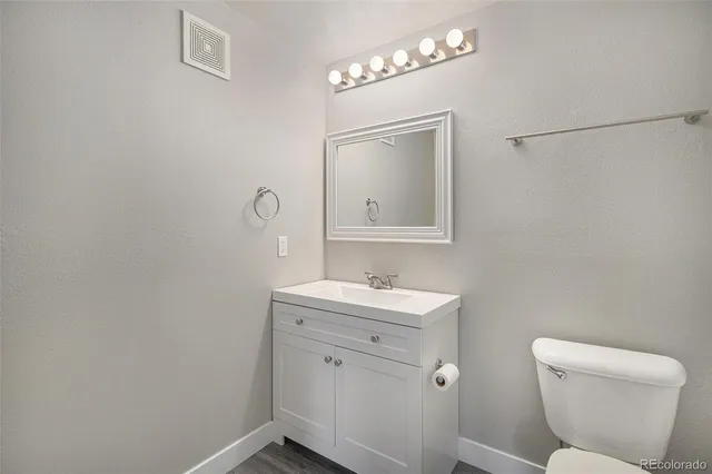 a bathroom with a toilet a sink and mirror