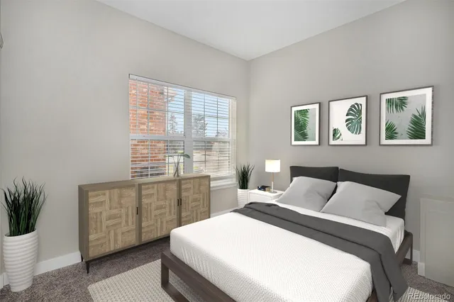 a bedroom with a large bed and a potted plant