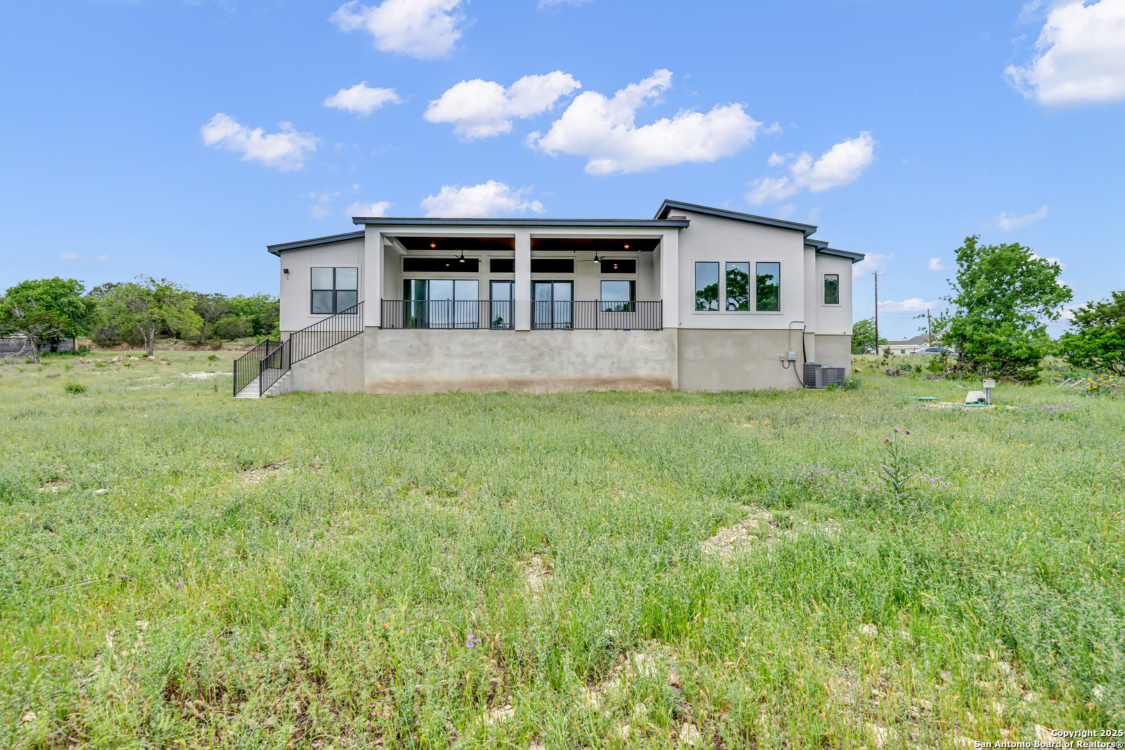 6846 Spring Branch Road Spring Branch, TX 78070 - Photo 15 of 46 a front view of house with yard and trees in the background