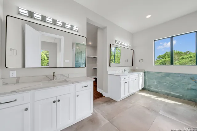 a bathroom with a bathtub sink and mirror