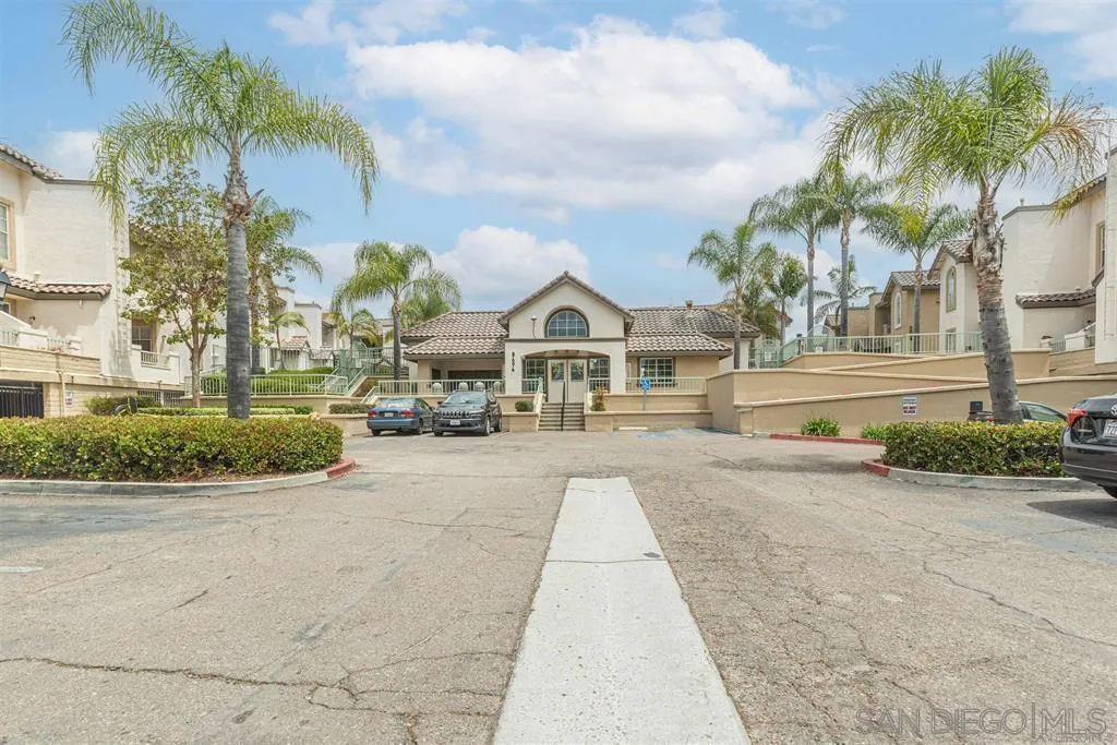 a front view of a house with a yard and palm trees