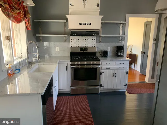 a kitchen with a stove and white cabinets
