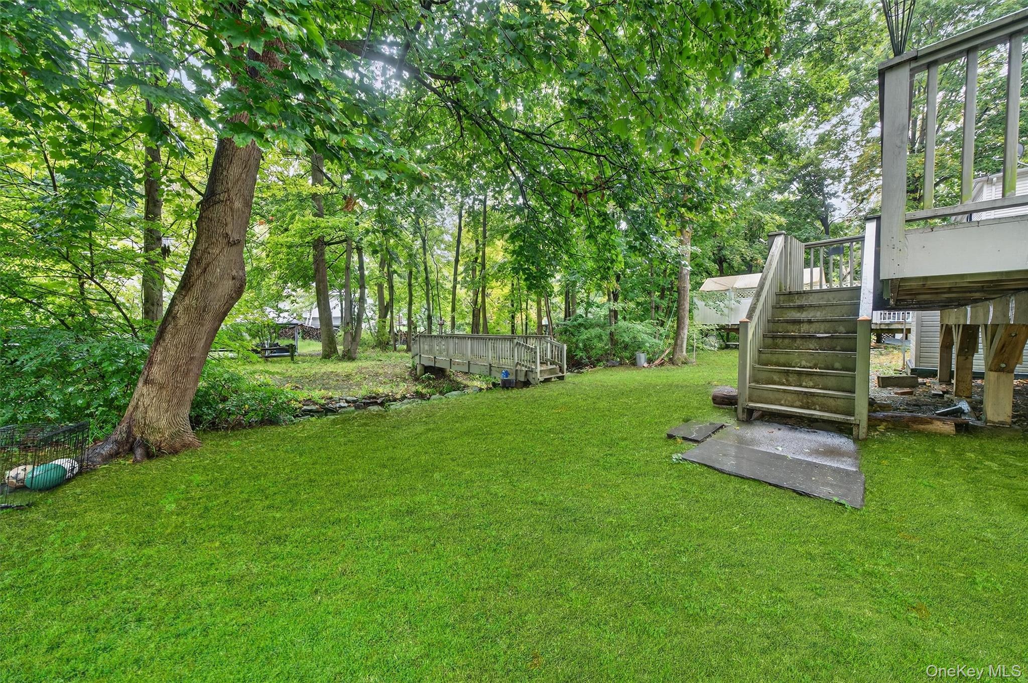 72 Smith Clove Road Central Valley, NY 10917 - Photo 28 of 35 View of green lawn with stairs, a deck, and view of scattered trees