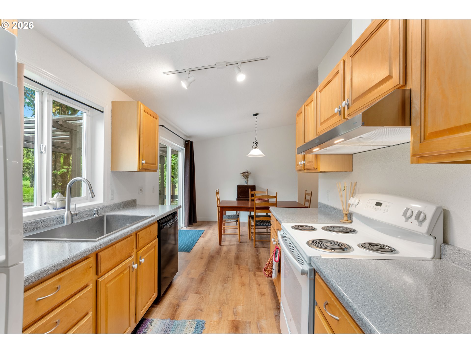 451 Cannavinna Road Carson, WA 98610 - Photo 14 of 33 a kitchen with stainless steel appliances granite countertop a stove a sink dishwasher and a dining table with wooden floor