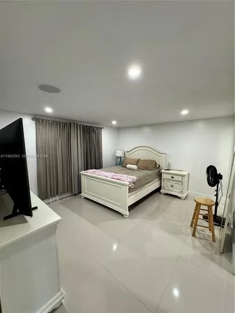 a bedroom with furniture and a large window