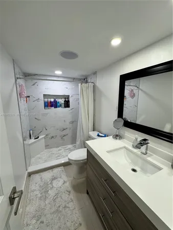 a bathroom with a sink a toilet and a mirror