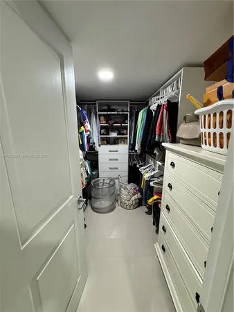 a view of walk in closet with clothes and shoes