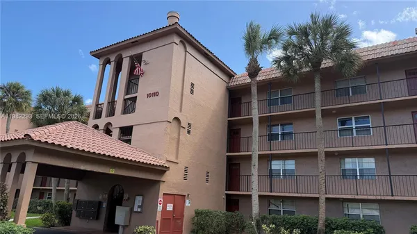 a view of a house with a garage and potted plants