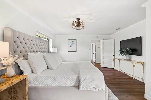 a bedroom with a bed and a flat screen tv