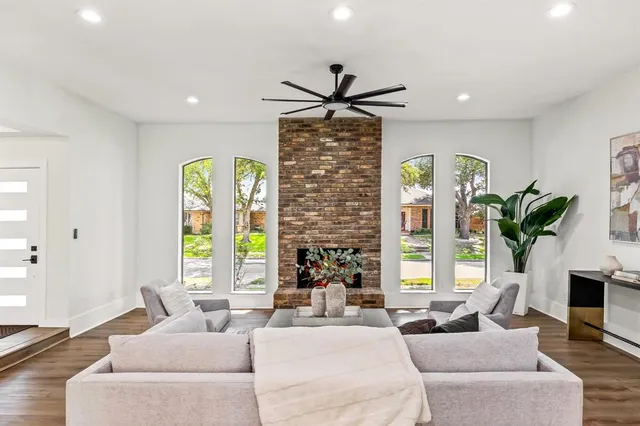 a living room with fireplace furniture and a large window