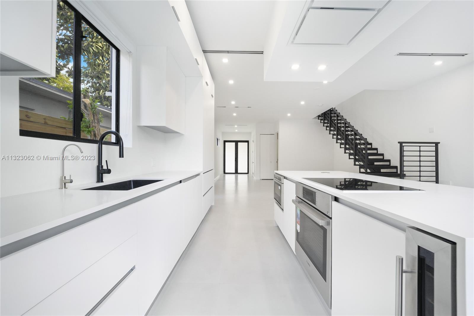 442 Southwest 15th Road Miami, FL 33129 - Photo 3 of 18 a view of a kitchen with kitchen island a sink stainless steel appliances and a window