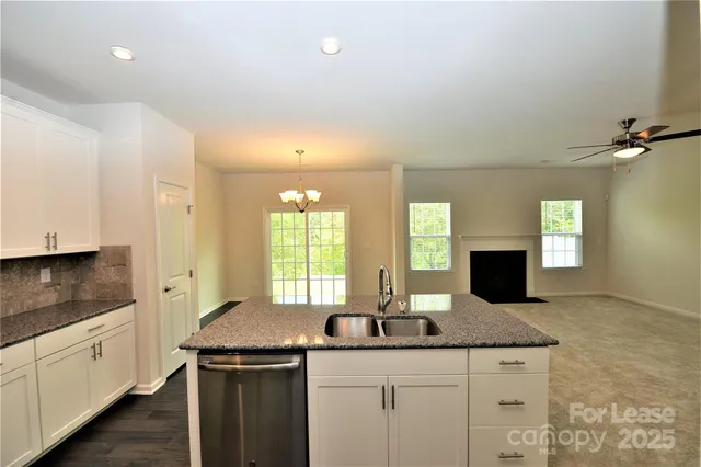 a kitchen with granite countertop a sink and cabinets