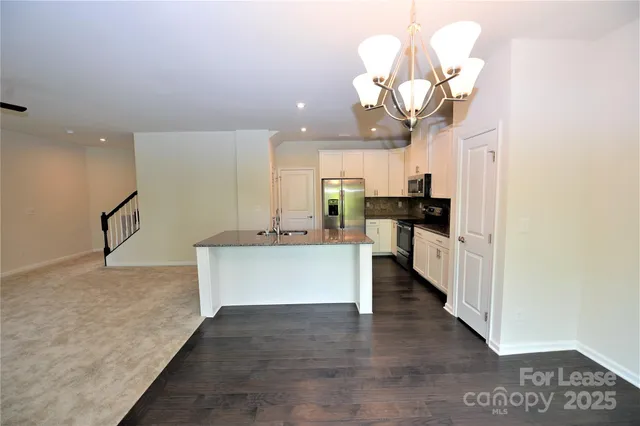 a view of kitchen with refrigerator stove microwave and cabinets