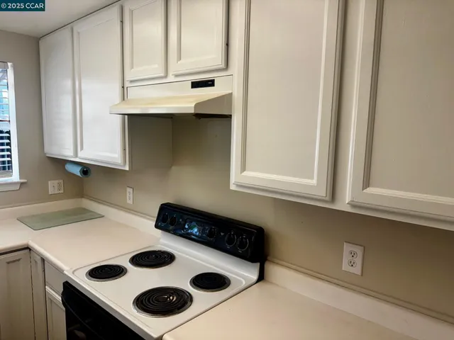 a kitchen with a sink a stove and cabinets