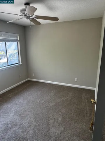 a view of a room with window and ceiling fan
