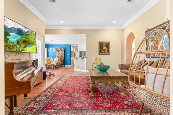 a dining room with furniture a chandelier and wooden floor