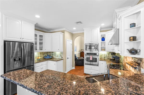 a kitchen with a sink a stove and cabinets