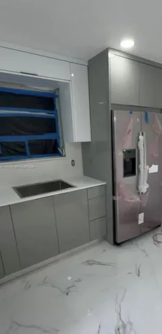 a kitchen with a refrigerator and a sink