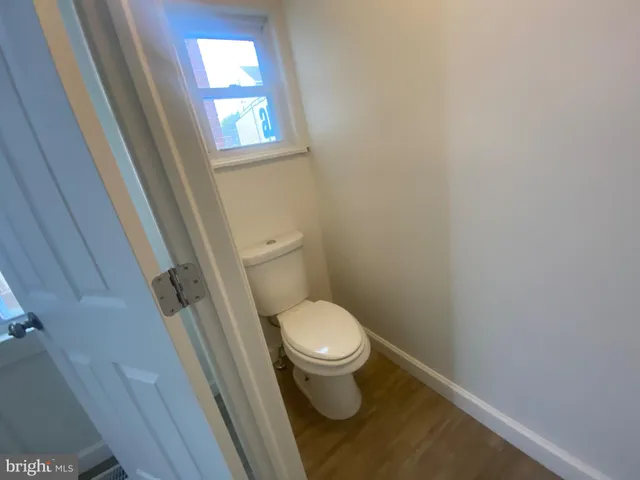 a white toilet sitting next to a window