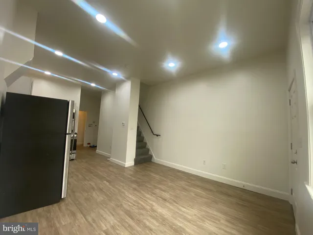 a view of a hall with wooden floor and a window
