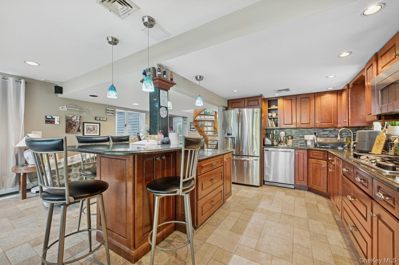 101 Bay Street Long Beach, NY 11561 - Photo 12 of 42 a kitchen with stainless steel appliances kitchen island granite countertop a table chairs and a refrigerator