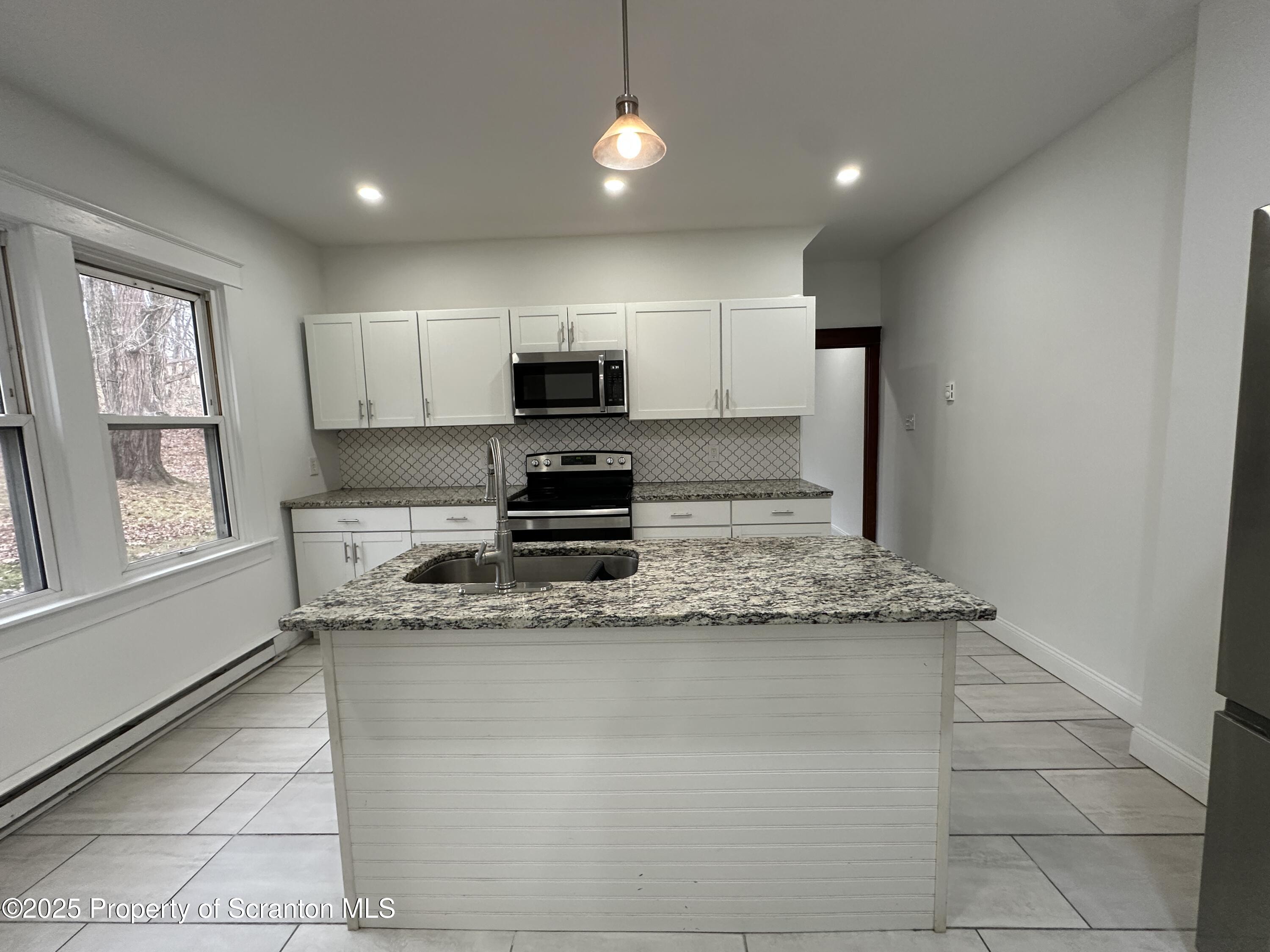 5 Robert Street Nanticoke, PA 18634 - Photo 17 of 26 a kitchen with kitchen island granite countertop a sink appliances cabinets and a counter top space