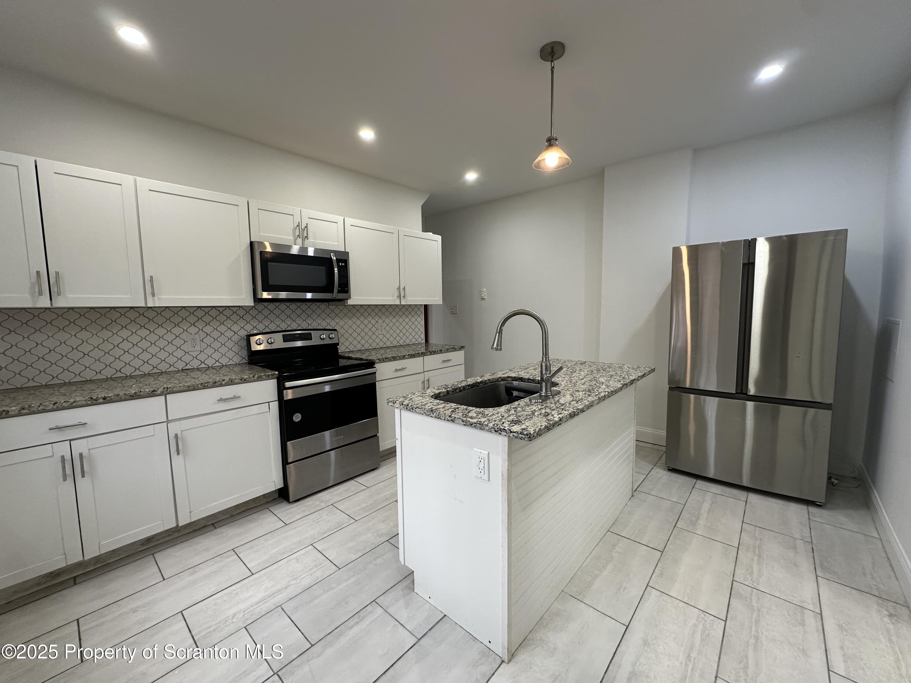 5 Robert Street Nanticoke, PA 18634 - Photo 4 of 26 a kitchen with stainless steel appliances granite countertop a stove a sink and a refrigerator