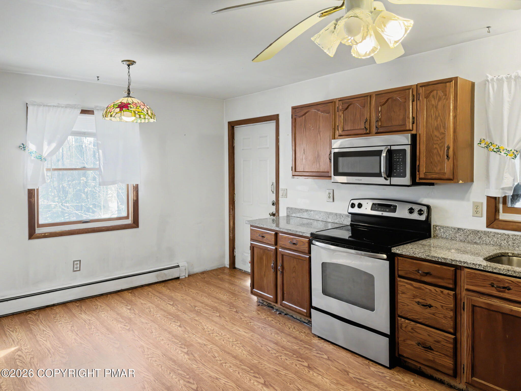 1208 Mattioli Road Bartonsville, PA 18321 - Photo 6 of 23 a kitchen with stainless steel appliances granite countertop a stove top oven a sink dishwasher a dining table and chairs with wooden floor