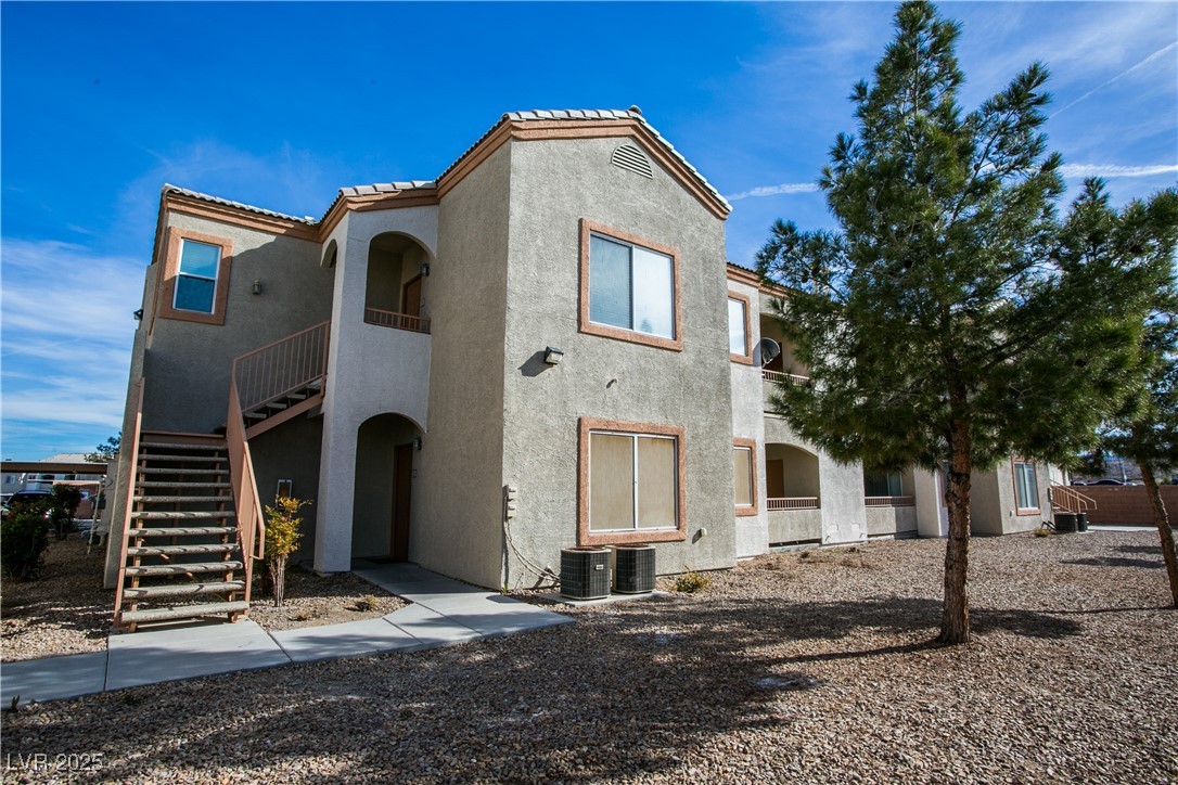 4655 Gold Dust Avenue, Unit 206 Las Vegas, NV 89120 - Photo 2 of 34 View of front facade with stairs, stucco siding, and a tiled roof
