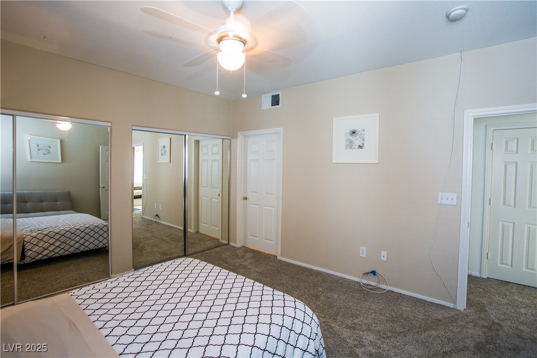 4655 Gold Dust Avenue, Unit 206 Las Vegas, NV 89120 - Photo 21 of 34 Carpeted bedroom with two closets and a ceiling fan