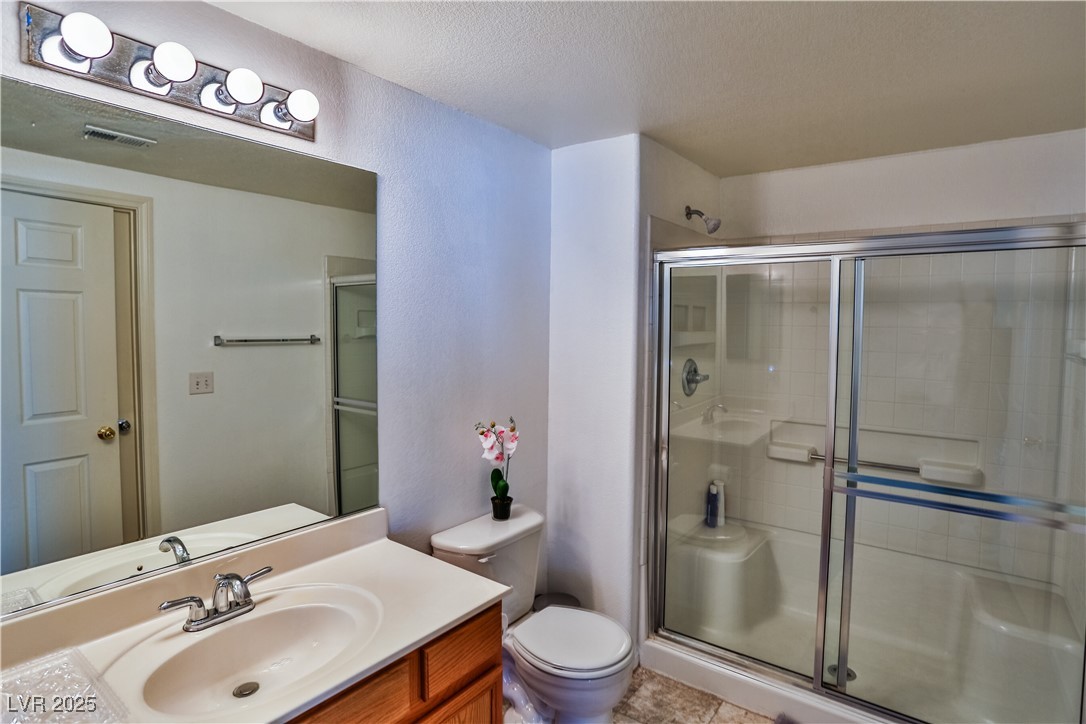 4655 Gold Dust Avenue, Unit 206 Las Vegas, NV 89120 - Photo 23 of 34 Bathroom featuring a shower stall, vanity, and a textured ceiling