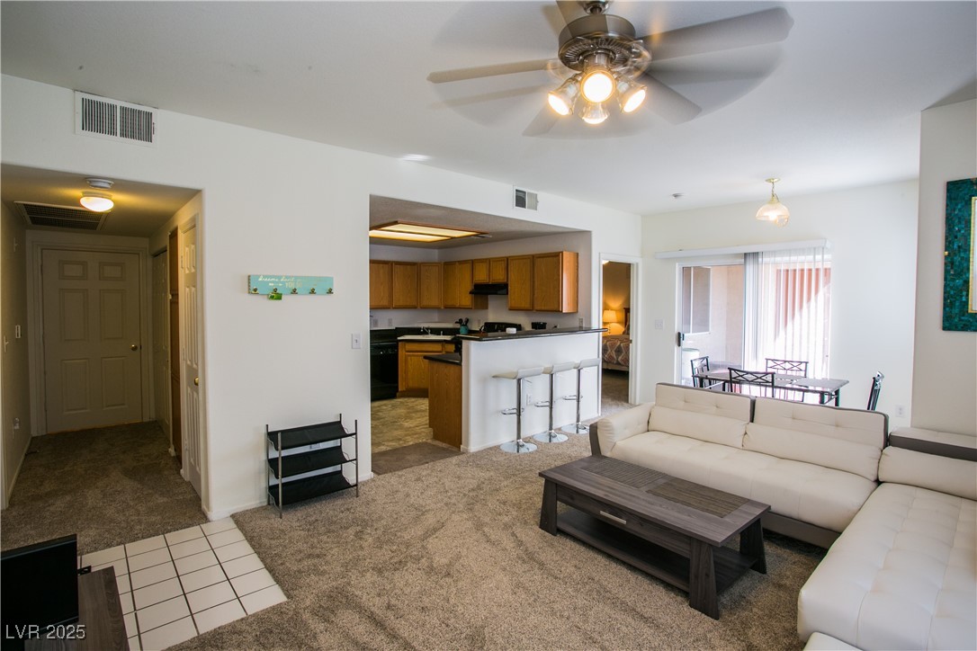 4655 Gold Dust Avenue, Unit 206 Las Vegas, NV 89120 - Photo 8 of 34 Living area featuring carpet, ceiling fan, and tile patterned floors