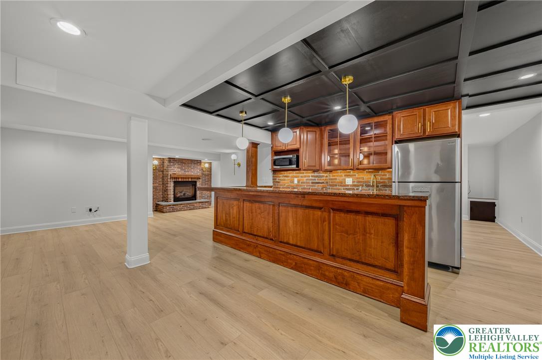 3130 Muirfield Road Center Valley, PA 18034 - Photo 46 of 63 Rich wood tones and brick accents define this finished lower level featuring a wet bar.
