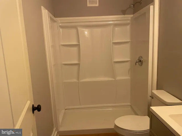 a bathroom with a toilet and a shower