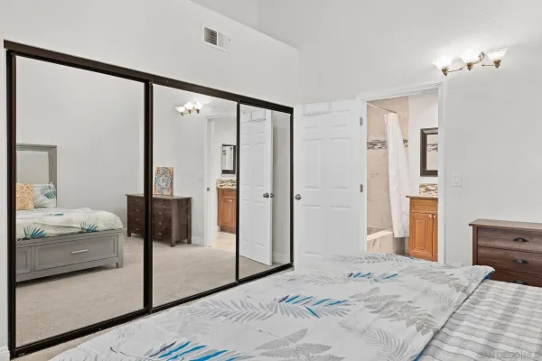 a bedroom with a balcony a bed and a walk in closet