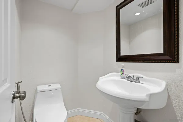 a bathroom with a toilet a sink and mirror