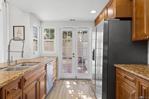 a kitchen with granite countertop a sink stove and refrigerator