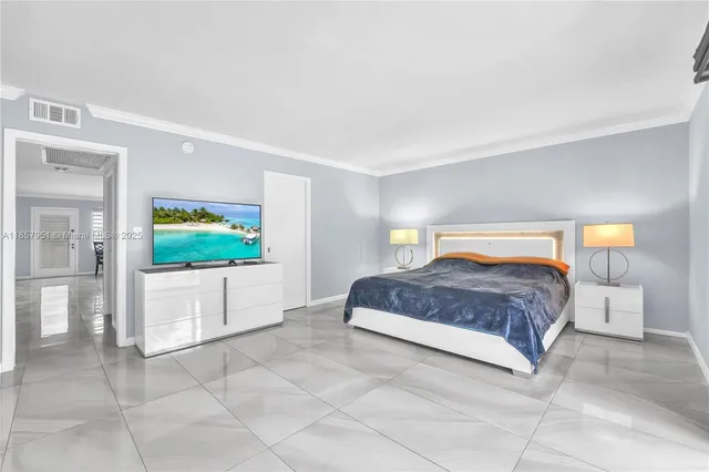 a bedroom with a large bed and a flat screen tv