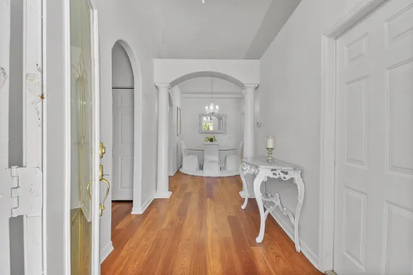 a view of a hallway with wooden floor and living room