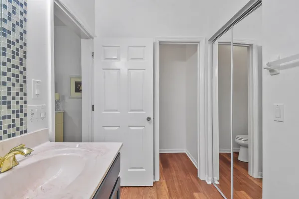 a bathroom with a granite countertop sink a mirror and shower