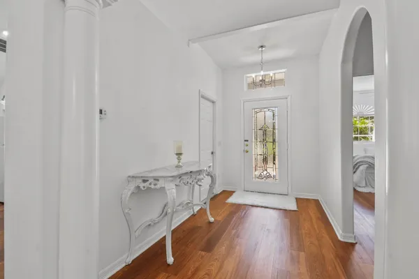 a view of a hallway with wooden floor and windows