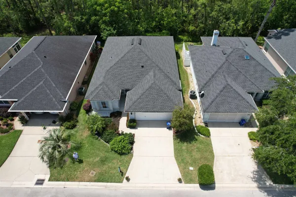an aerial view of multiple houses with a yard
