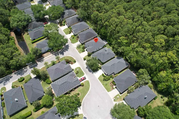 an aerial view of a house with a yard and lake view