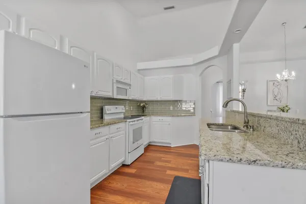 a kitchen with stainless steel appliances granite countertop a sink and a stove top oven