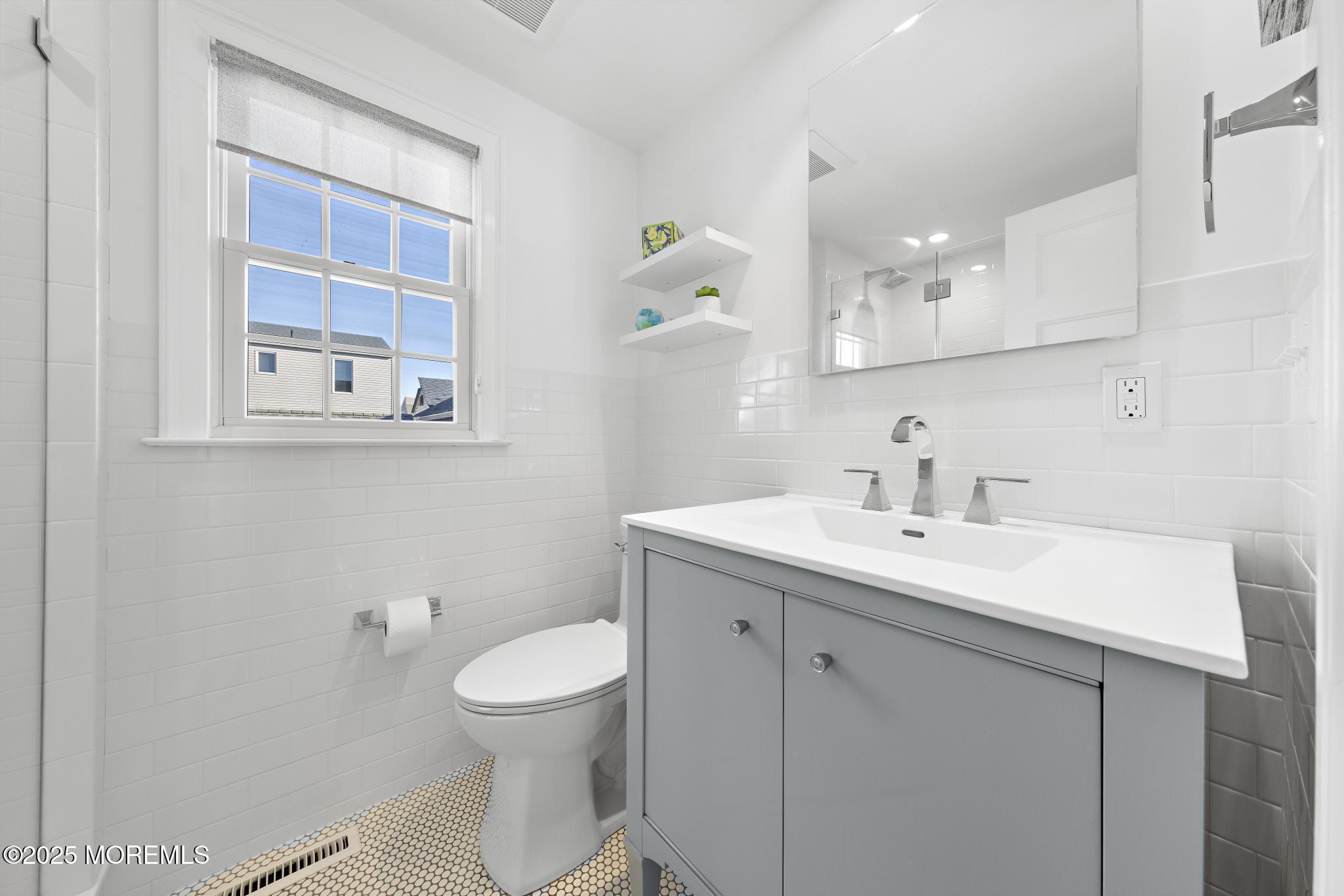 9 Inlet Road Beach Haven, NJ 08008 - Photo 23 of 51 a bathroom with a toilet a sink and mirror
